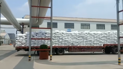 工廠廠區(qū)內，工作人員正在裝車運輸產品，展示生產線的高效運作。